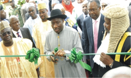 President Goodluck Jonathan (middle) cutting the tape to inaugurate the new Federal High Court complex in Minna yesterday while Niger State Governor, Babangida Aliyu (left) and Chief Judge of Federal High Courts, Justice Ibrahim Auta (right) and Minister of Justice, Mohammed Adoke (SAN), watch