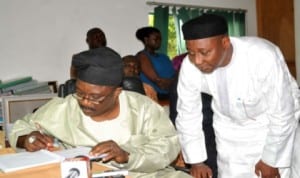 Chairman, Senate Committee on FCT. Senator  Smart Adeyemi, signing a condolence register at the NUJ Secretariat in Abuja in honour of three journalists who died in an auto crash, last tuesday. With him is the NUJ President Malam Garba Mohammed.