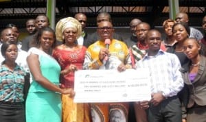 Governor Peter Obi of Anambra State (middle), presenting a Dummy Cheque of N160 million to some of the 160 first class graduates of the state to enable them establish themselves in their chosen careers in Awka last Thursday. Photo: NAN.