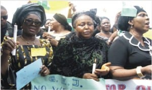 Minister of State for Foreign Affairs 1, Prof. Viola Onwuliri (left), holding a lighted candle symbolising the light that will drive away darkness in Nigeria during a protest over abducted Chibok School Girls in Owerri On Tuesday.