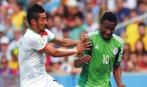 Super Eagles midfielder, Mikel Obi trying to beat Iraniam player during the World Cup match last Monday