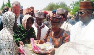  Minister of Finance, Dr Ngozi Okonjo-Iweala (2nd right), presenting relief materials to internally displaced persons, during her visit to the refugees camp in Maiduguri last Wednesday. With her are Governor Kashim Shettima of Borno State (right) and Director-General, National Emergency Management Agency, Alhaji Mohammed Sidi (middle). 