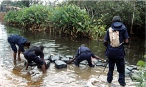 Officers of Nigeria Security and Civil Defence Corps (NSCDC) recovering jerry cans used in siphoning petrol from pipe lines at Oke Isawo in Ikorodu, Lagos State, last Friday