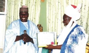 Adamawa Deputy Governor-elect, Mr  Martins   Babale (left), presenting his Certificate of Return to Gangwari of  Ganye, Alhaji  Umaru Sanda, for the royal father’s blessing at the Chamba Kingdom Palace in Ganye LGA, last Wednesday.