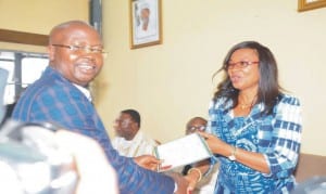 Member, House of Representatives-elect for Udi/Ezeagu Federal Constituency of Enugu State, Mr Dennis Amadi receiving his Certificate of Return from Inec returning officer, Dame Gladys Nwafor in Enugu  last Friday.