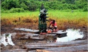  A resident fetching crude from residual crude oil leakage from Adebewa  well 8 at Edagberi community, Ahoada West LGA in Rivers State on Monday