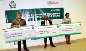 L-R: Second Runner Up Winner, Japhter Obinna, representative of the Grand Winner, Mr Boyonle Ogunlana, and representative of the First Runner Up Winner, Miss Temitayo Jaiyesimi, displaying their dummy cheques, during presentation of Cbn e-payment Incentive Scheme (Epis) Raffle Cash Reward in Abuja recently